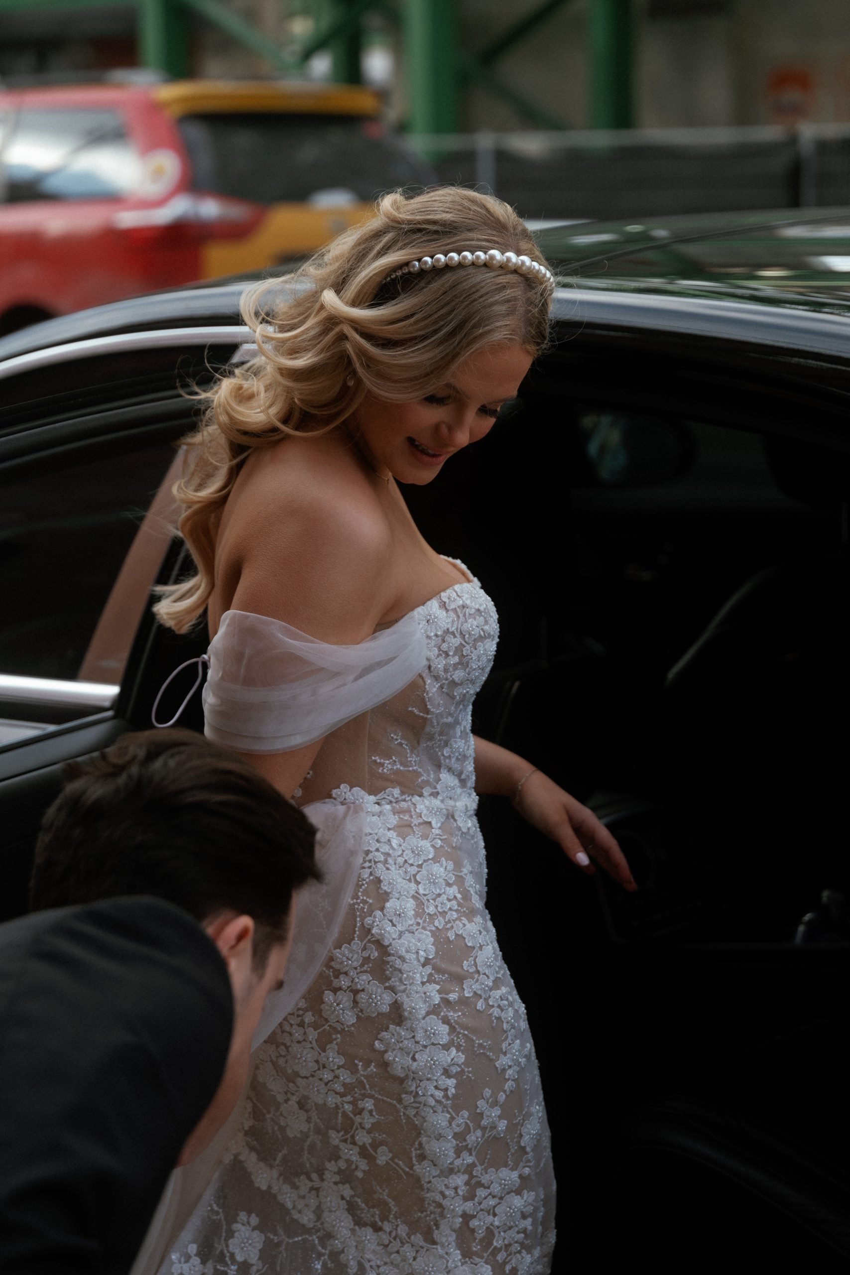 bride gets ready to enter vintage car on the way to the wedding reception