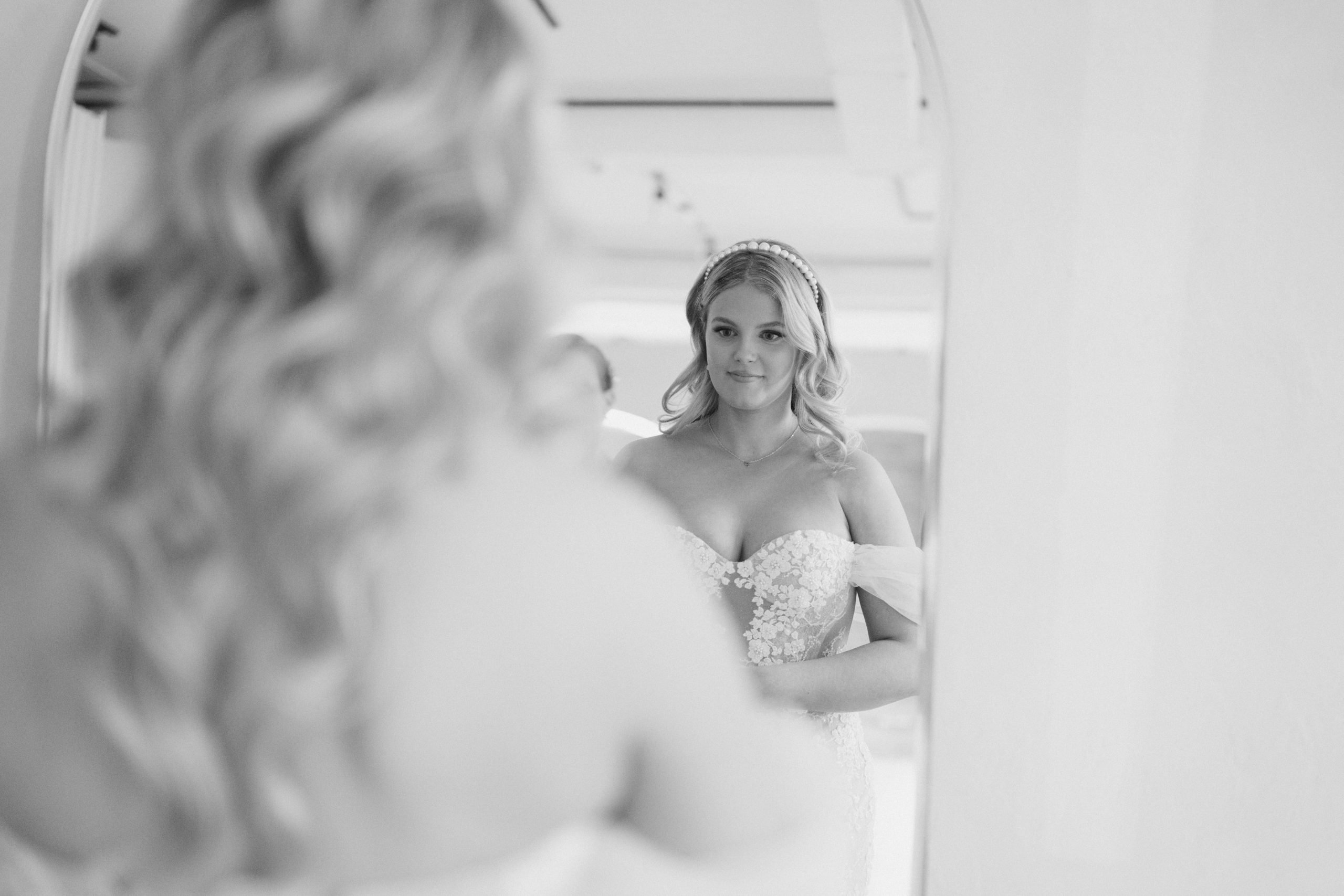 bride looks at herself in the mirror before the first look, at Archive studios